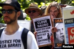 FILE - Protesters react as they hold placards and listen to speakers during a rally in support of refugees in central Sydney, Australia, Oct. 19, 2015.