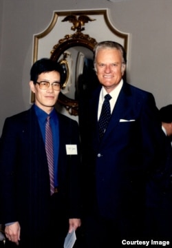 流亡美国的中国政治学者严家祺和葛培理牧师，摄于1988年。（受访者提供）