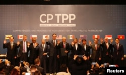 Representatives of members of Trans-Pacific Partnership (TPP) trade deal: Brunei's Acting Minister for Foreign Affairs Erywan Dato Pehin, Chile's Foreign Minister Heraldo Munoz, Australia's Trade Minister Steven Ciobo, Canada's International Trade Minister Francois-Phillippe Champagne, Singapur's Minister for Trade and Industry Lim Hng Kiang, New Zealand's Minister for Trade and Export Growth David Parker, Malaysia's Minister for Trade and Industry Datuk J. Jayasiri, Japan's Minister of Economic Revitalization Toshimitsu Motegi, Mexico's Secretary of Economy Ildefonso Guajardo Villarreal, Peru's Minister of Foreign Trade and Tourism Eduardo Ferreyros Kuppers and Vietnam's Industry and Trade Minister Tran Tuan Anh, wave as they pose for an official picture after the signing agreement ceremony in Santiago, Chile, March 8, 2018.