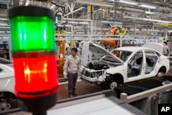 FILE - A worker assembles a car at a factory for Chinese automaker BAIC Motor in Beijing.