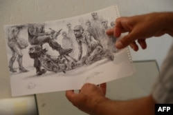 Syrian artist and painter Najah al-Bukai presents his work during an AFP interview, Aug. 20, 2018 in Yerres. France.