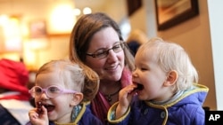 FILE - Michelle Moore poses for a photo with her twin daughters, Sierra (right) and Savannah in Lake Oswego, Oregon. Moore is among the vaccine skeptics who have been widely ridiculed since more than 100 people fell ill in a measles outbreak traced to Disneyland.
