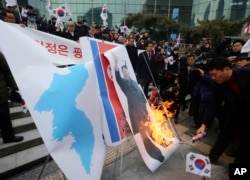 South Korean protesters burn a portrait of North Korean leader Kim Jong Un during a rally against a visit of North Korean Hyon Song Wol, head of North Korea's art troupe, in front of Seoul Railway Station in Seoul, Jan. 22, 2018.