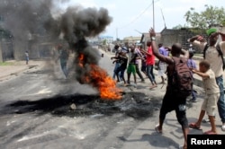 FILE – In January 2015, demonstrators burned tires to set up barricades during a protest over proposed changes to an election law in the Democratic Republic of Congo's capital Kinshasa.