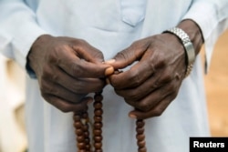 FILE - A Muslim holds Prayer beads outside a mosque in the town of Koui, Central African Republic, April 27, 2017.