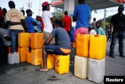 People stand in line waiting to buy fuel, in Port-au-Prince, Haiti, Feb. 13, 2019.