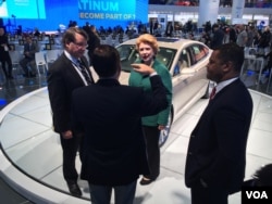 U.S. Senator Gary Peters, U.S. Senator Debbie Stabenow, and Assistant Secretary of Commerce for Industry and Analysis Marcus Jadotte tour the Ford exhibit during the first press day at the 2016 North American International Auto Show in Detroit. (K. Farabaugh/VOA)
