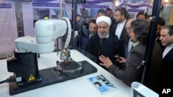 IIn this photo released by an official website of the office of the Iranian Presidency, President Hassan Rouhani listens to explanations on new nuclear achievements at a ceremony to mark "National Nuclear Day," in Tehran, Iran, April 9, 2018.
