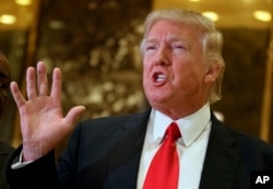 FILE - Donald Trump, at the time still president-elect, speaks with reporters in the lobby of Trump Tower in New York, Jan. 13, 2017. Trump has yet to provide evidence to support his wiretapping claims.