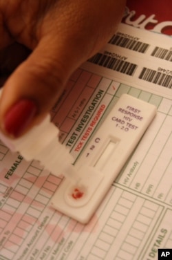 Makiwane puts a drop of blood into the test card, while Marais waits for the result