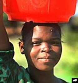 A woman in urban area carrying water for a long distance