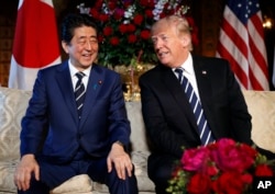 President Donald Trump and Japanese Prime Minister Shinzo Abe smile during their meeting at Trump's private Mar-a-Lago resort, April 17, 2018, in Palm Beach, Florida.