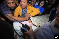 Aides use a blanket to cover Indonesian House Speaker Setya Novanto who lies on a stretcher as he is transferred to Cipto Mangunkusumo Hospital in Jakarta, Indonesia, Nov. 17, 2017.