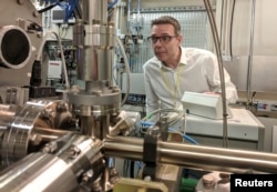 Professor John McGeehan, an X-ray Crystallographer at the University of Portsmouth, stands next to equipment at the Diamond Light Source, the UK national synchrotron, that he used to reveal the atomic structure of an enzyme.