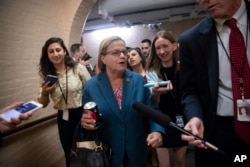 Rep. Ileana Ros-Lehtinen, R-Fla., who was born in Cuba and brought to the U.S. by her parents, is pursued by reporters as she leaves a closed-door GOP meeting in the basement of the Capitol as the Republican leadership tries to reach a policy agreement between conservatives and moderates on immigration, in Washington, June 7, 2018.