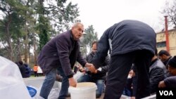 Local men organize soup kitchen on the back of a truck at makeshift refugee camp along Greek-Macedonian border, in Idomeni, Greece, March 16, 2016. (J. Dettmer/VOA)