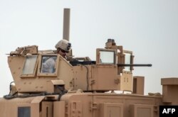 A U.S. soldier sits atop an armored vehicle on a road in Syria's northern Deir Ezzor province, Feb. 21, 2019.