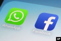 FILE - WhatsApp and Facebook app icons are shown on a smartphone.