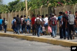 FILE - Central American migrants cross into Mexico from Guatemala, near Ciudad Hidalgo, Mexico, June 4, 2019.