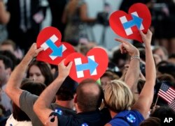 Supporters for Democratic presidential candidate Hillary Clinton hold up campaign logos during a presidential primary election night rally in New York, June 7, 2016..