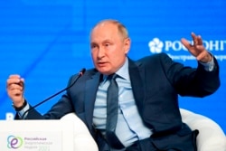FILE - Russian President Vladimir Putin gestures while speaking at the plenary session of the Russian Energy Week in Moscow, Russia, Oct. 13, 2021.