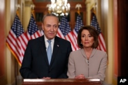 FILE - House Speaker Nancy Pelosi, right, and Senate Minority Leader Chuck Schumer pose for photographers after speaking on Capitol Hill in response President Donald Trump's prime-time address on border security, in Washington, Jan. 8, 2019.