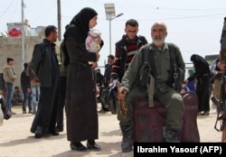 Syrians who were evacuated from the rebel-held town of Harasta in eastern Ghouta arrive at a camp for displaced people in Maaret al-Ikhwan, in Syria's rebel-held Idlib province, March 23, 2018.