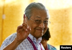 Mahathir Mohamad, former Malaysian prime minister and opposition candidate for Pakatan Harapan (Alliance of Hope), holds up an ink-stained finger as he votes during the general election in Alor Setar, Malaysia, May 9, 2018.