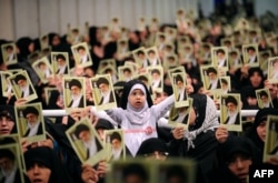 Picture released by the official website of Iranian Supreme Leader Ayatollah Ali Khamenei shows Iranian women and a girl holding up portraits of him during a meeting in Tehran, Feb. 17, 2014.