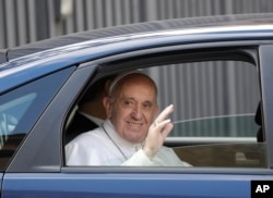 Pope Francis salutes as he leaves the St. John in Lateran Basilica after meeting parishioners in Rome, March 2, 2017.