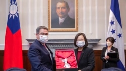 FILE - In this photo released by the Taiwan Presidential Office, outgoing Honduran President Juan Orlando Hernandez, left, exchanges gifts with Taiwanese President Tsai Ing-wen during a meeting in Taipei, Taiwan, Nov. 13, 2021.