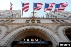 FILE - Flags fly above the entrance to the new Trump International Hotel on its opening day in Washington, Sept. 12, 2016.