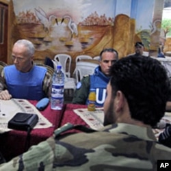The Chief of the U.N. Supervision Mission to Syria, Norwegian Major-General Robert Mood (L) and his team meet members of the Free Syrian Army at al-Khalidiya neighborhood during a visit to Homs on May 3, 2012.