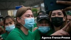 FILE - Sara Duterte, left, mayor and daughter of outgoing Philippines President Rodrigo Duterte, poses for a selfie with city hall employees in Davao on Nov. 9, 2021.