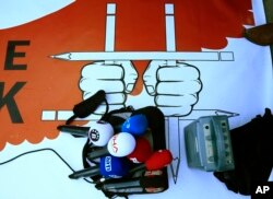 Broadcast equipment is placed on a poster during a protest outside a court where the trial of about a dozen employees of the Cumhuriyet daily newspaper on charges of aiding terror groups, continues in Istanbul, Oct. 31, 2017.