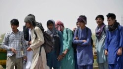 Afghan men wait in queue to cross into Iran at an Afghan-Iran border crossing in Zaranj on Sept. 8, 2021.