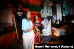 Petugas imigrasi Malaysia menahan dua perempuann yang diduga pekerja migran ilegal dari Indonesia dalam sebuah operasi di Nilai, di luar Kuala Lumpur, pada 1 September 2013. (Foto: Reuters/ Bazuki Muhammad)