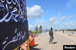 FILE - Members of al-Qaida's Nusra Front man a checkpoint in Idlib.