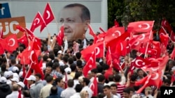 Supporters wave flags backdropped by a large picture of Turkish PM Erdogan as they wait for his arrival in Ankara, June 9, 2013.