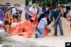 FILE - Orlando city employees and volunteers fill sandbags for residents as they prepare for Hurricane Irma in Orlando, Florida, Sept. 8, 2017. Lines of vehicles stretched for miles and many waited several hours to get the sandbags.