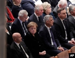 Britain's Prince Charles, second from left, back row, and German Chancellor Angela Merkel, second from left, bottom row, are shown seated during a State Funeral for former President George H.W. Bush.