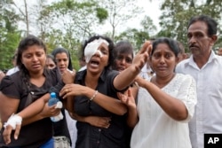 FILE - Anusha Kumari, center, weeps during a mass burial for her husband, two children and three siblings, all victims of Easter Sunday's bomb attacks, in Negombo, Sri Lanka, April 24, 2019.