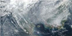 Citra satelit yang menggambarkan kabut asap lintas batas yang berasal dari Indonesia di 2015 dan 2019 yang dipublikasi dalam laporan Greenpeace berjuldul Karhutla Dalam Lima Tahun Terakhir. (Foto: VOA/Yoanes Litha)