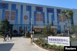 FILE - People walk at the R&D center of Contemporary Amperex Technology Ltd. in Ningde, Fujian province, China, Dec. 16, 2016.