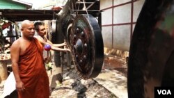 Panna Jota, who traveled 600 kilometers from Mon state to purchase a modest-sized gong at the Mandalay workshop, inspects a gong. (Z. Aung/VOA)