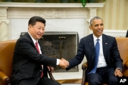 FILE - President Barack Obama shakes hands with Chinese President Xi Jinping during their meeting in the Oval Office of the White House in Washington, Sept. 25, 2015.