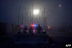 Members of the U.S. Border Police guard the international bridge in Texas, as seen from Piedras Negras, Coahuila state, Mexico, Feb. 6, 2019.