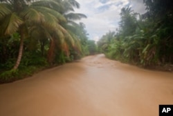 A river fed by the Massif de la Hotte watershed runs brown because of deforestation upstream.