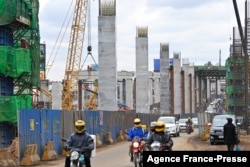 FILE - Motorists drive on Mombasa road, next to the construction site of the Nairobi Expressway, undertaken by the Chinese contractor China Road and Bridge Corporation (CRBC), in Nairobi, Kenya, July 12, 2021.