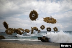 FILE - Amphibious assault vehicles of the South Korean Marine Corps fire smoke bombs as they come ashore during a U.S.-South Korea joint landing operation drill as a part of the two countries' annual military training called Foal Eagle, in Pohang, South Korea, April 2, 2017.